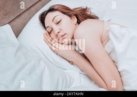 Asian Woman schläft entspannt auf einem großen, geräumigen Bett zu Hause oder in einem Hotel Stockfoto