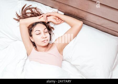 Asian Woman schläft entspannt auf einem großen, geräumigen Bett zu Hause oder in einem Hotel Stockfoto