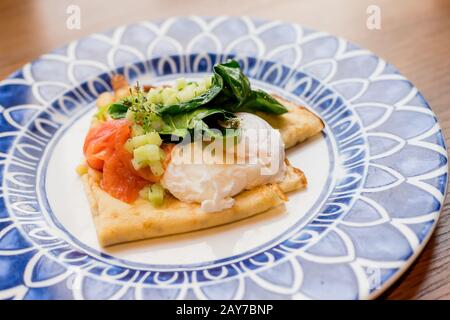 Herzhafte Crêpes mit Lachs und pochiertem Ei Stockfoto