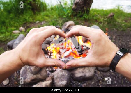 Die Hände der Männer erwärmen sich um das Feuer Stockfoto