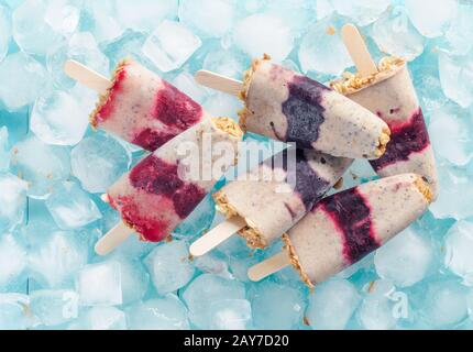 Eis am Stiel mit Früchten, Müsli und Chia Samen. Ansicht von oben Stockfoto