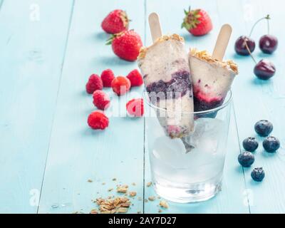 Eis am Stiel mit Früchten, Müsli und Chia Samen. Exemplar Stockfoto