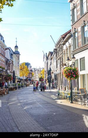 Venlo, Limburg-Niederlande - 13. Oktober 2018: Straße mit Cafés, Restaurants und Bars im historischen Zentrum der niederländischen Stadt. Menschen, die auf der Straße spazieren. Vertikales Foto. Stockfoto