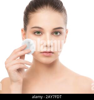 Junge Frau sorgt für die Gesichtshaut. Reinigung der perfekte frische Haut mit Wattepad. Isoliert. Stockfoto