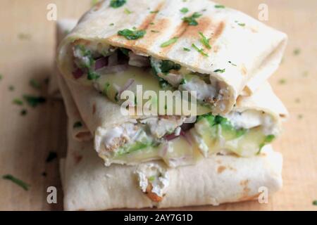 Burrito mit Huhn und Avocado. Leckeres und gesundes Abendessen. Hausgemachte Burrito. Tortilla mit Huhn und Käse. Stockfoto