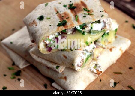 Burrito mit Huhn und Avocado. Leckeres und gesundes Abendessen. Hausgemachte Burrito. Tortilla mit Huhn und Käse. Stockfoto