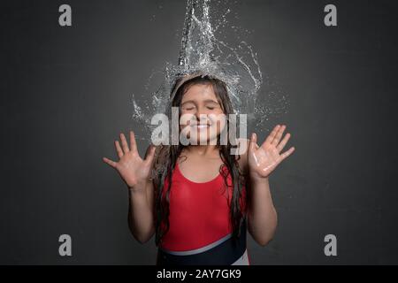 Junges Mädchen fangen Wasser von oben Stockfoto