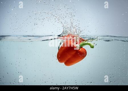 Einzelner Pfeffer wird in Wasser abgeworfen Stockfoto