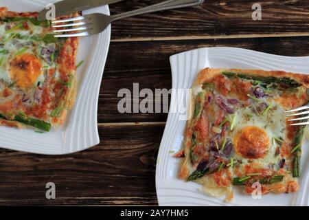 Ein köstlicher und schmackhafter Snack. Blätterteig mit Lachs, Ei und Spargel. Gefülltes Blätterteig, schneller Snack. Köstliches Frühstück. Stockfoto