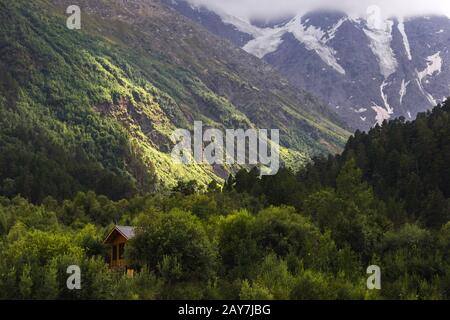 Vertikale Landschaft, das Sonnenlicht, das durch die Wolken bricht, beleuchtet lokal den Handabschnitt am Fuß des Kaukasus Stockfoto