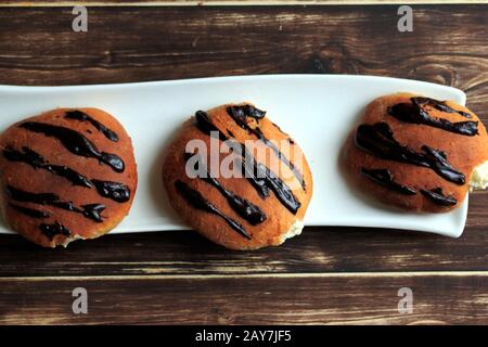 Hausgemachte Donuts mit Schlagsahne. Leckere süße Brötchen. Hausgemachtes Brot. Stockfoto