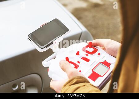 Der junge Mann hält ein Kontrollfeld für den Drohnen-Quadrocopter Stockfoto