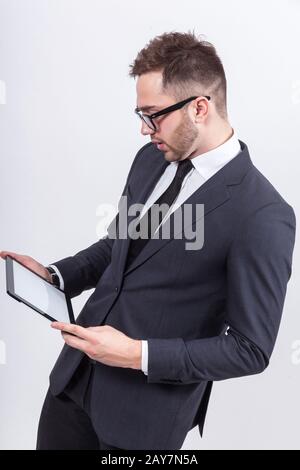 Ein Bild von einem ernsthaften Unternehmer, der mit einem Tablet steht Stockfoto