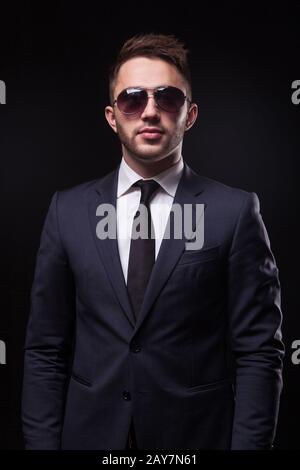 Elegante, trendige Geschäftsmann in einen Anzug und Sonnenbrille auf Stockfoto