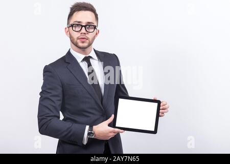 Ein Bild von einem ernsthaften Unternehmer, der mit einem Tablet steht Stockfoto