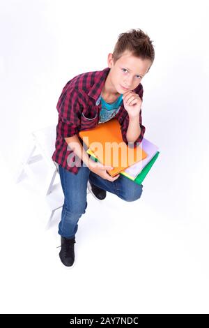 Müde Schüler europäischer Auftritt in Hemd und Jeans sitzend o Stockfoto