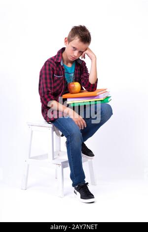 Müde Schüler europäischer Auftritt in Hemd und Jeans sitzend o Stockfoto