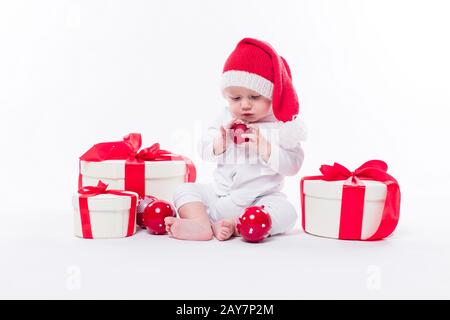 Schönes Baby in der Neujahrskappe und weißer Körper sitzt unter B. Stockfoto