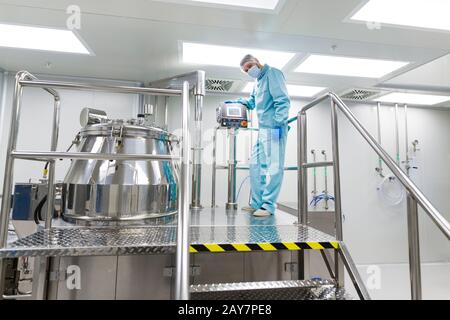 Wissenschaftler suchen in Stahl Tank im Labor Stockfoto