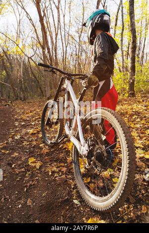 Porträt eines jungen Fahrers in vollem Schutz einer Gesichtshelmmaske und Handschuhe auf einem Fahrrad Stockfoto