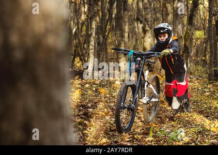 Porträt eines jungen Fahrers in vollem Schutz einer Gesichtshelmmaske und Handschuhe auf einem Fahrrad Stockfoto