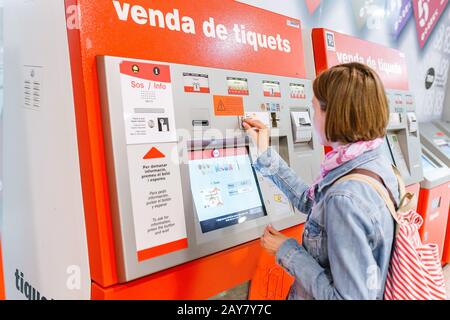 09. JULI 2018, BARCELONA, SPANIEN: Reisende Frau kauft ein Ticket an einem öffentlichen Transport-Automaten TMB an der U-Bahn-Station Stockfoto