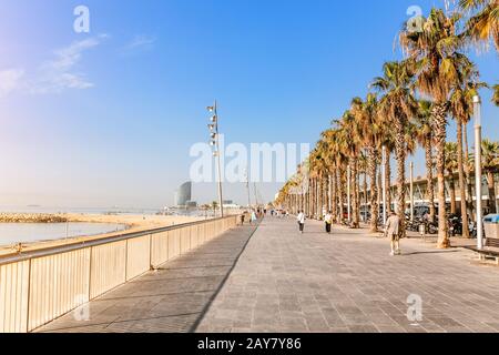 09. JULI 2018, BARCELONA, SPANIEN: Menschen, die am frühen Morgen an der Küste von La Barceloneta spazieren gehen. Hochsaison Konzept Stockfoto