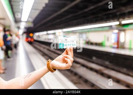 10. JULI 2018, BARCELONA, SPANIEN: Reisender von Frauen hält T-10-Ticket für den öffentlichen Nahverkehr in Barcelona in der U-Bahn Stockfoto