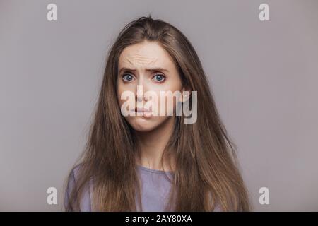 Beleidigt stressige weibliche Bisse Unterlippe mit Unzufriedenheit, hat schmerzhaften Ausdruck, drückt negative Emotionen aus, ist nach Streit im niedrigen Geist Stockfoto