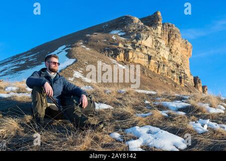 Auf der Natur sitzt das Porträt des beschaulichen Hipper-Reisenden mit Bart in einer Sonnenbrille. Stockfoto