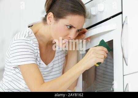 Frau hat zuhause den Backofen aufgenährt Stockfoto