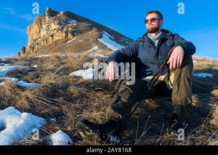 Auf der Natur sitzt das Porträt des beschaulichen Hipper-Reisenden mit Bart in einer Sonnenbrille. Stockfoto