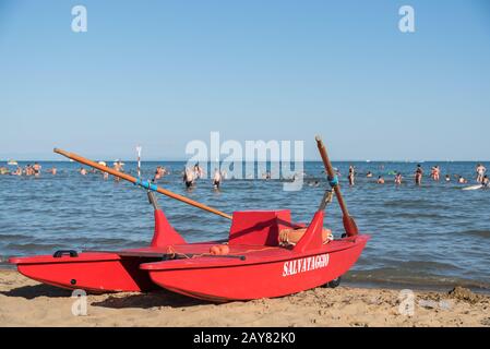 Rotes Ruderboot am Strand eines italienischen Badeortes Stockfoto