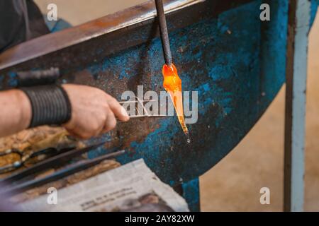 Künstler Man Hands Closeup Arbeitet an einer Form eines heißen Glases in der Werkstatt Stockfoto