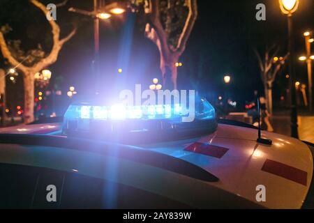 Polizeiwagen mit Blitzlicht nachts auf der Straße Stockfoto