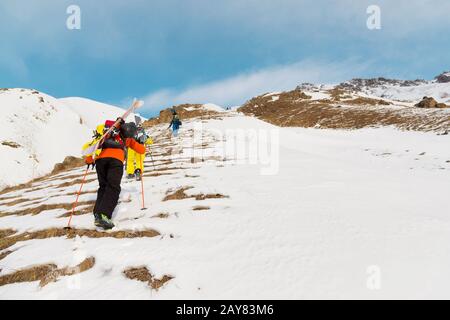 Eine Gruppe von drei Freeridern erklimmen den Berg für den Backcountry Ski entlang der wilden Pisten des Stockfoto
