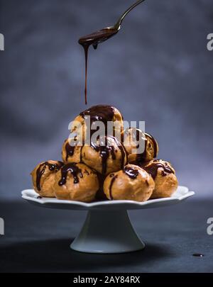 Profiteroler Turm mit Schokolade überfüllen Stockfoto