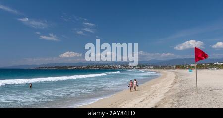 Brisas de Zicatela, Oaxaca, Mexiko - Der Strand des Pazifischen Ozeans mit Blick auf Puerto Escondido. Die rote Fahne warnt vor gefährlichen Schwimmbedingungen. Stockfoto