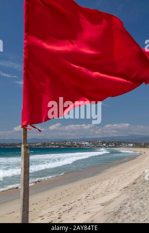 Brisas de Zicatela, Oaxaca, Mexiko - Der Strand des Pazifischen Ozeans mit Blick auf Puerto Escondido. Die rote Fahne warnt vor gefährlichen Schwimmbedingungen. Stockfoto