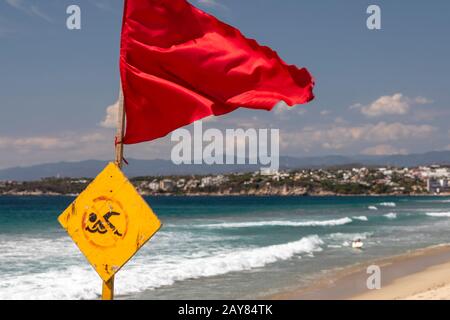 Brisas de Zicatela, Oaxaca, Mexiko - Der Strand des Pazifischen Ozeans mit Blick auf Puerto Escondido. Die rote Fahne warnt vor gefährlichen Schwimmbedingungen. Stockfoto