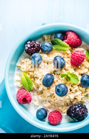 Leckeres und leichtes Frühstück mit Müsli und Cornflakes mit gesumteren Früchten, Wohlfühlkonzept. Stockfoto