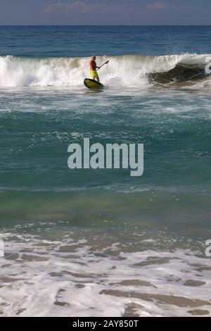 Brisas de Zicatela, Oaxaca, Mexiko - EIN Mann paddelt ein Surfbrett auf dem Pazifischen Ozean. Stockfoto