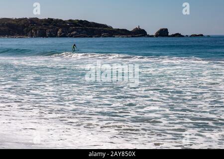 Brisas de Zicatela, Oaxaca, Mexiko - EIN Mann paddelt ein Surfbrett auf dem Pazifischen Ozean. Stockfoto