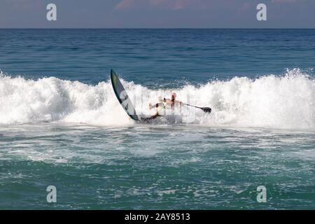 Brisas de Zicatela, Oaxaca, Mexiko - EIN Mann paddelt ein Surfbrett auf dem Pazifischen Ozean. Stockfoto