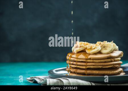 Ahorn-Sirup über Pfannkuchen schütten Stockfoto