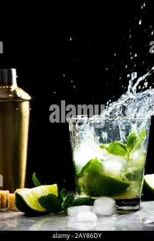 Stürmen Sie im Glas Mojito mit fliegenden Tropfen Cocktail Stockfoto