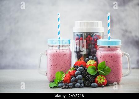 Hausgemachter Beerensmoothie in Gläsern und Mixer Stockfoto