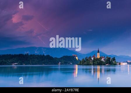 Gewitter über Bled See und Kirche, Slowenien Stockfoto