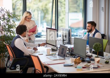 Gruppe von drei Kollegen im Open Space Office: Teamarbeit, Erfolg, Geschäft Stockfoto
