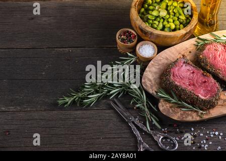 Rohes Rinderfilet Steak mit Kräutern und Salat Stockfoto
